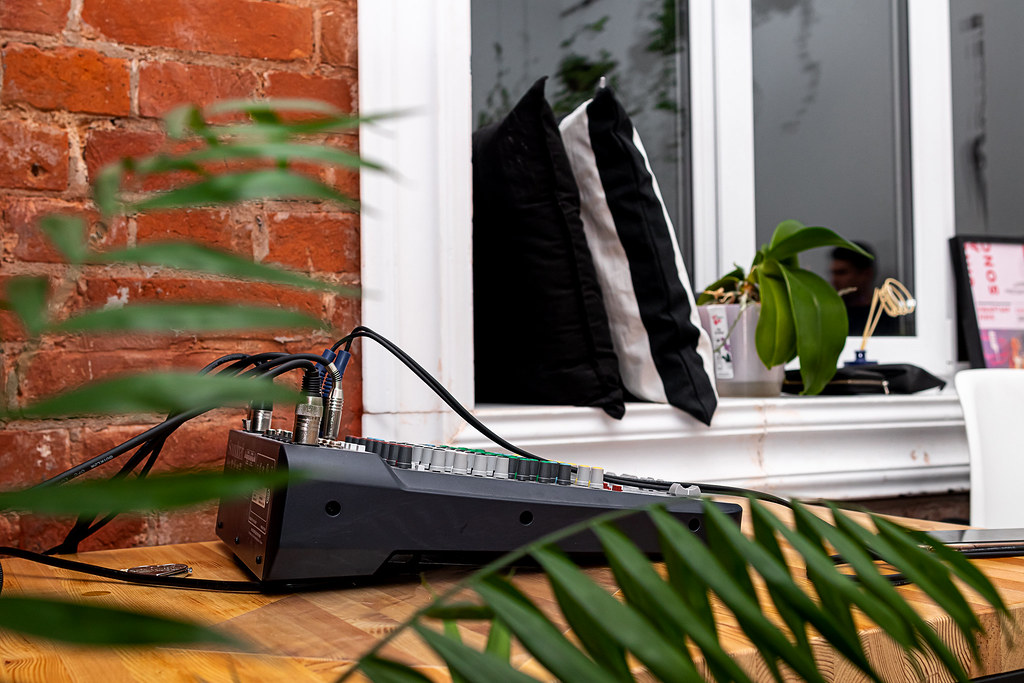An audio mixing desk on a wooden table in a home studio